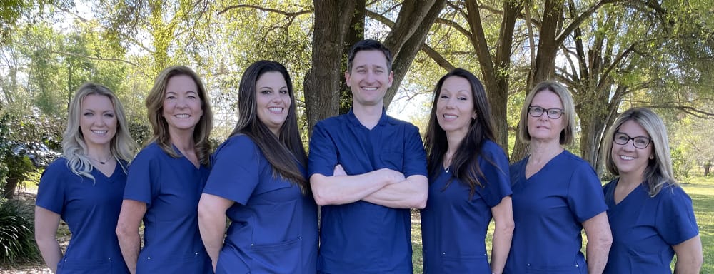 The full staff standing under a tree